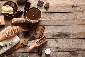 Beautiful spa composition with bowls of melted chocolate and massage body brush on wooden background