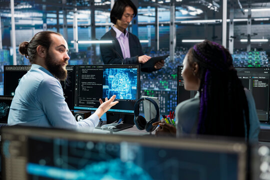 Manager and female programmer in server room using PC to review infrastructure diagnostics. IT specialist teaching trainee during internship in data center, analyzing performance data