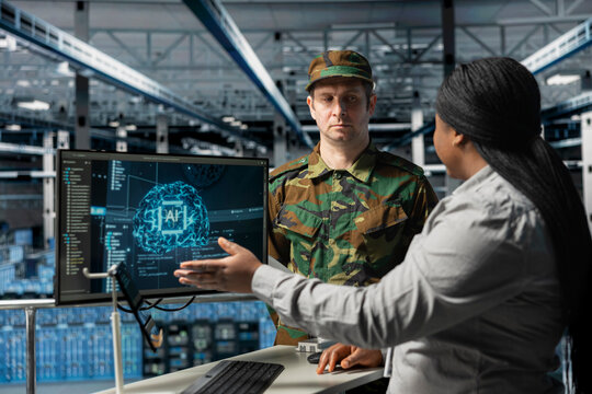 Server farm workers interpreting artificial intelligence systems output during mission planning. Army tech expert in data center coordinating efforts with commander, using AI tools