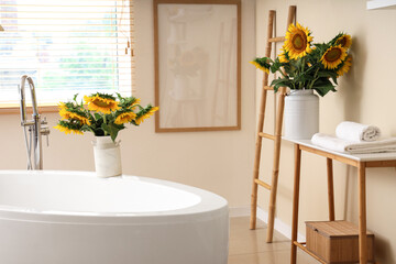 Bouquets of sunflowers in interior of bathroom