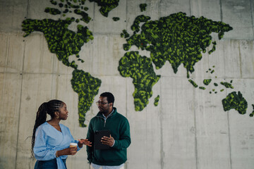 Colleagues discussing global sustainability in modern office