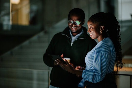 Business colleagues collaborating late at night using tablet