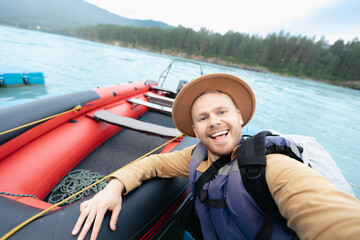 Happy Young caucasian male adventurer on inflatable boat enjoys outdoor excursion