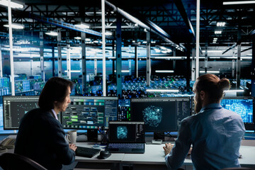 Fototapeta premium Team of engineers working together in data center, optimizing hardware for AI tasks, increasing workloads. Teamworking server hub colleagues automating system diagnostics using deep learning