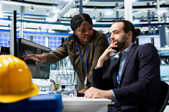 Multiethnic group of solar energy experts and technicians evaluates system, promoting industrial innovation and engineering excellence. Corporate sustainability initiatives for growth.