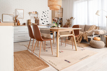 Interior of kitchen decorated for Halloween with white counters, sofa and dining table