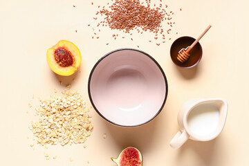 Empty bowl with oatmeal, milk and ingredients on beige background