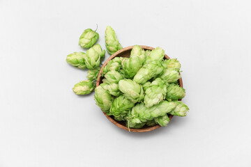 Bowl of green hops cones on white background