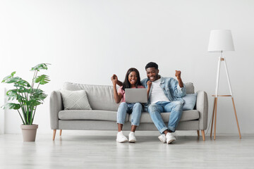Great Job, Win And Luck Concept. Excited black couple using pc laptop, cheering looking at screen,...