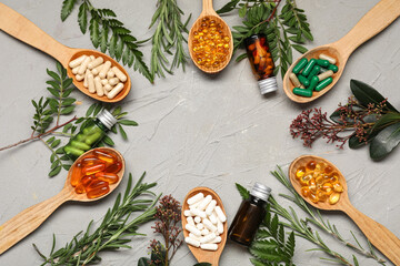 Naklejka premium Frame made of different pills and fresh herbs on grey background
