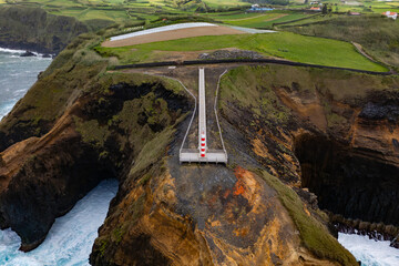 Aerial landscape rugged rocks with lighthouse and ocean in norther part Sao Miguel island, Azores