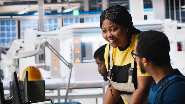 African american colleagues analyze power data from solar production line, teamwork gathered around desktop computer. Engineers optimizing configurations for sustainable energy. Camera A. - Powered by Adobe