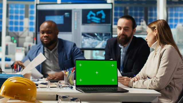 Factory engineers study schematics, refining production layouts using chroma key laptop. Experts outlining industrial plant configurations for prototypes using isolated screen notebook, camera B - Powered by Adobe