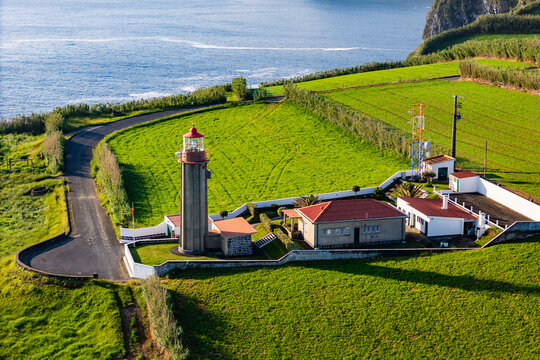Lighthouse on cape Cintrao with Cliffs and Green Fields and Atlantic Ocean. Azores, Sao Miguel Island, Aerial View