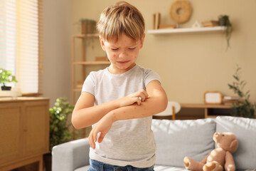 Little boy ill with chickenpox scratching his arm at home