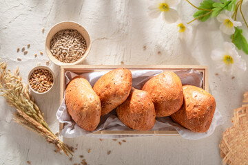 Homemade and hot buns with wheat, flowers and ears.