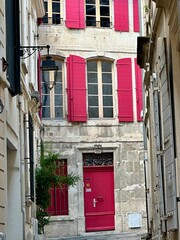 village house with red shutters down alley