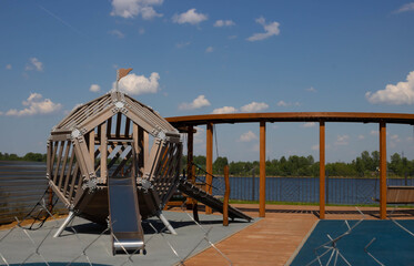 On a clear day, an empty playground in the courtyard of a residential complex, under a beautiful blue sky