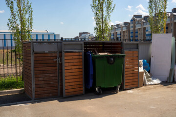 On a warm summer day, a garbage area in a city courtyard. A garbage collection area with garbage...