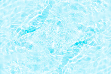 Blue water with ripples on the surface. Defocus blurred transparent blue colored clear calm water surface texture with splashes and bubbles. Water waves with shining pattern texture background.