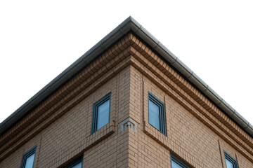 Building corner featuring light brown brickwork, windows, and a grey gutter against a solid transparent background, captured from a low angle. background removed