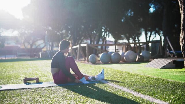 black woman athlete seated stretching hamstring on mat