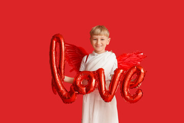 Obraz premium Cute little happy boy dressed as cupid with word LOVE made of balloons on red background. Valentine's Day celebration