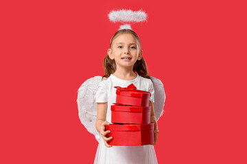 Obraz premium Cute little girl dressed as Cupid with gift boxes on red background. Valentine's Day celebration