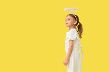 Obraz premium Cute little girl dressed as Cupid on yellow background. Valentine's Day celebration