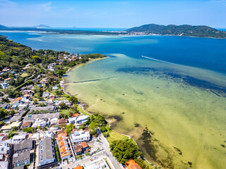 Aerial view of Conceicao lake with houses, dunes and forest