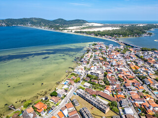 Aerial view of Conceicao lake with houses, dunes and forest
