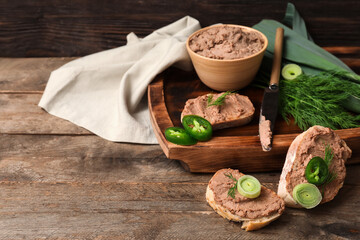 Tray with toasts, bowl of tasty pate, jalapeno pepper slices, green onion and dill on wooden...