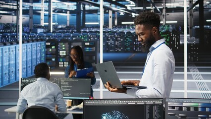 Data center system administrator analyzing infrastructure issues using node tree tools. Man in server hub using AI visualization insights on laptop to optimize system health, camera A