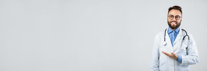 A doctor wearing a white coat and stethoscope smiles warmly while gesturing. The background is simple and bright, highlighting the doctor's friendly demeanor and professionalism.