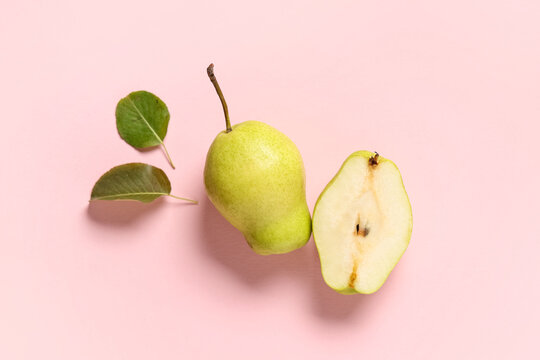 Sweet ripe pears and leaves on pink background
