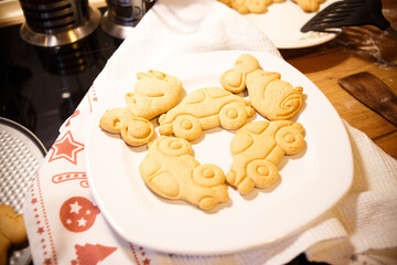 Homemade shaped cookies on a white plate — baked car and animal cookies for kids, fun family cooking concept