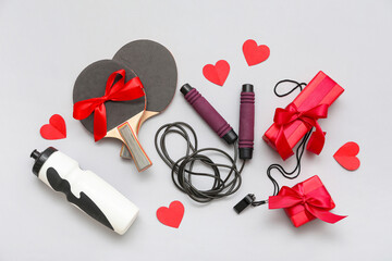 Fototapeta premium Composition with sports equipment, gifts and red paper hearts for Valentine's Day celebration on grey background