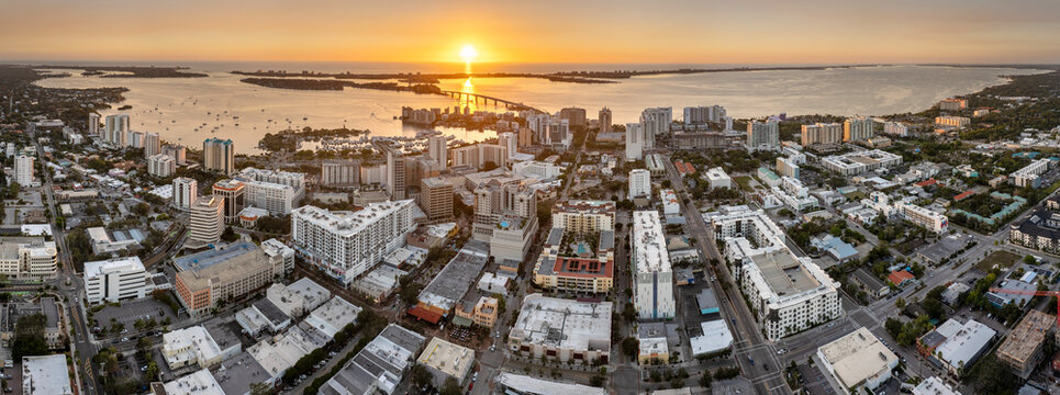 Aerial view of Sarasota city downtown at sunset with high-rise office buildings and Ringling Bridge on horizon. Real estate development in Florida. USA travel destination