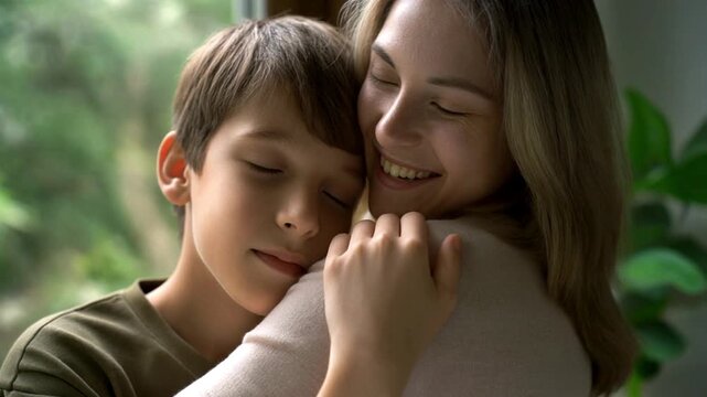 A smiling mother holds her young son close in a warm and comforting embrace, a tender moment of family connection