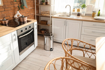 Interior of kitchen with counters and trash bin
