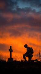 Fototapeta premium Soldier Silhouette Kneeling by Grave Cross at Sunset
