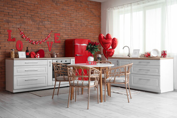 Interior of festive kitchen with dining table, roses and heart-shaped balloons. Valentine's Day celebration