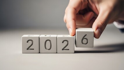 Hand arranging wooden blocks to complete the year '2026', representing the arrival of a new year, strategic planning, future goals, and the start of a fresh cycle