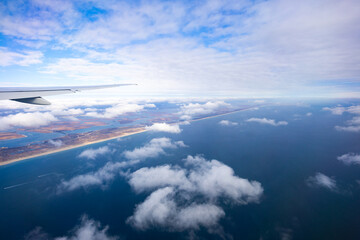 View from above of an airplane flying over the coast of North America.