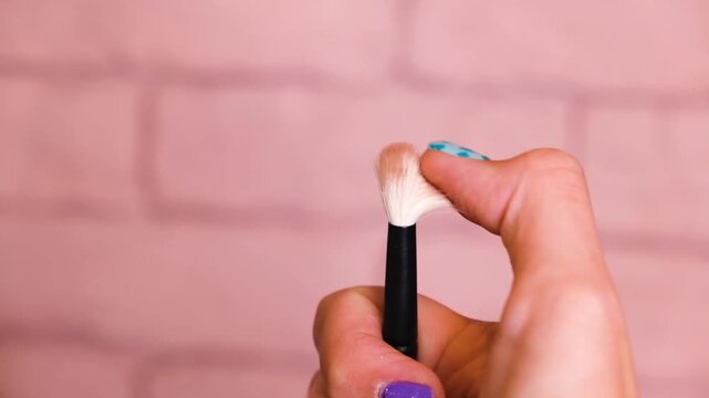 a lady put her hand on make up brush