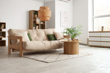Interior of light living room with sofa, coffee table and drawers