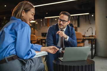 Business professionals discussing work in co-working office space