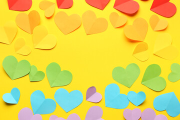 Frame made of colorful paper hearts on yellow background. Valentine's Day celebration
