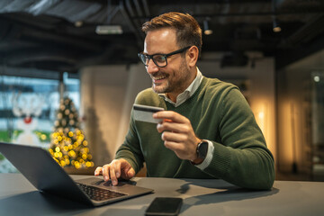 Man doing online shopping with credit card and laptop