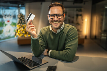 Happy man holding credit card for online shopping